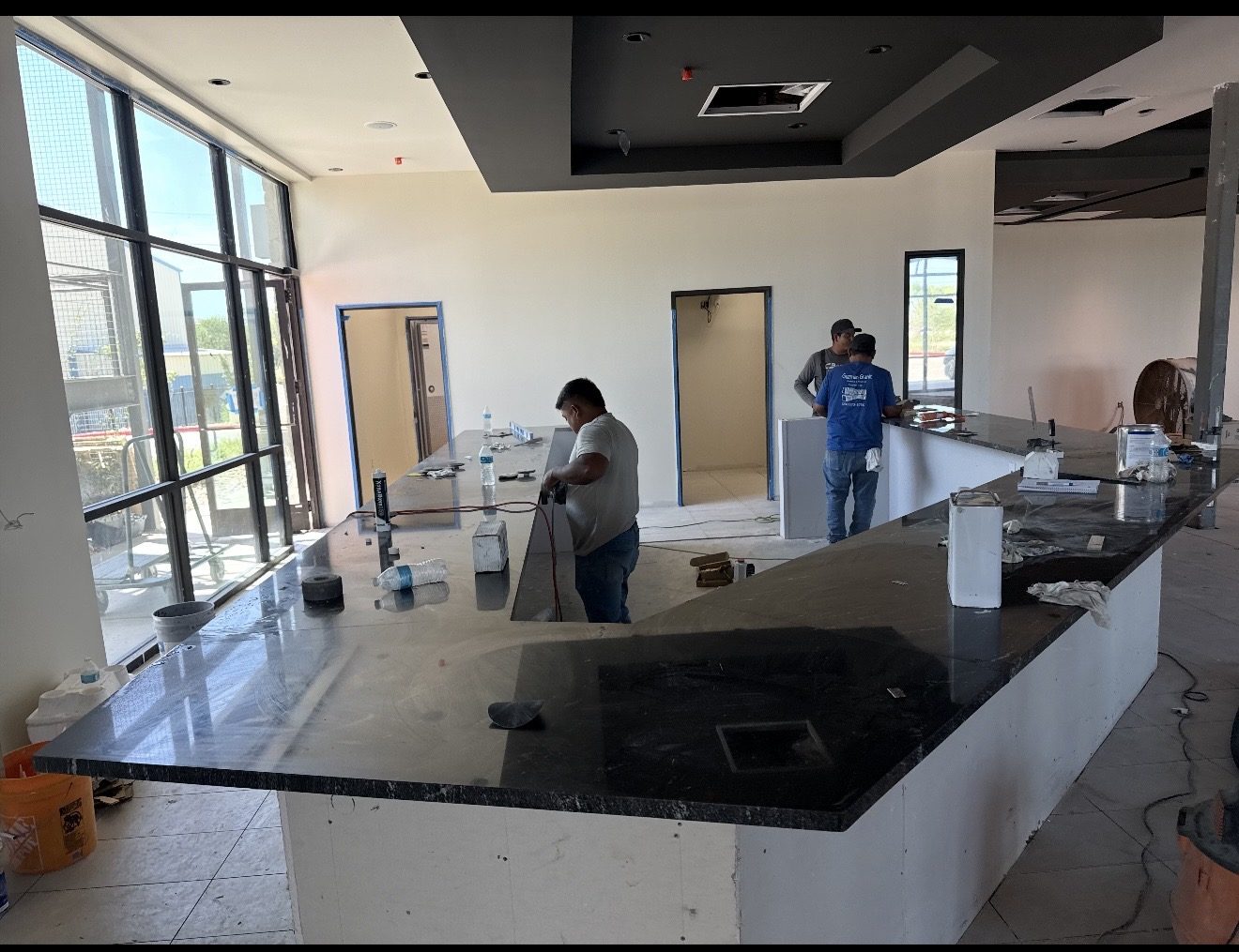 Granite Guru installers finishing a black granite commercial counter on site in San Antonio TX