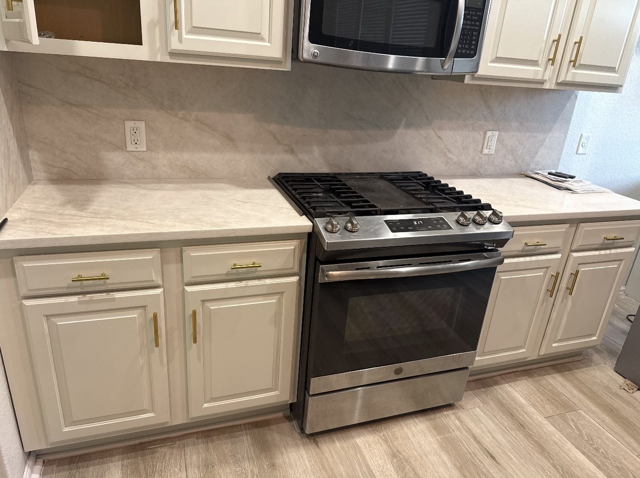 Marble-look quartz kitchen countertops with full-height backsplash and cream cabinets, San Antonio TX