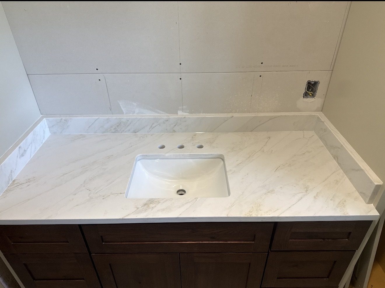 Marble-look quartz bathroom vanity top with backsplash on wood cabinets, San Antonio TX