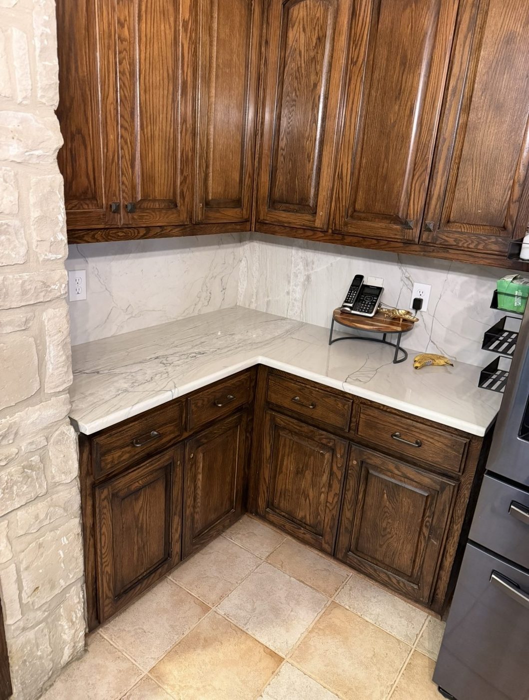 Quartzite countertops with full-height veined backsplash on oak cabinets, San Antonio TX